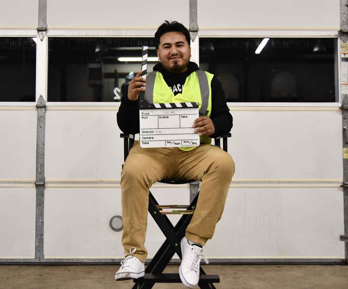 man sitting in director chair with clipboard