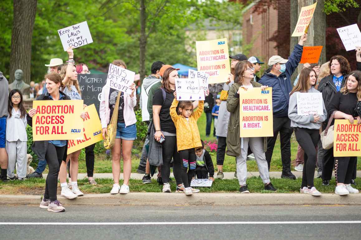 people stand with protest signs supporting abortion access. 