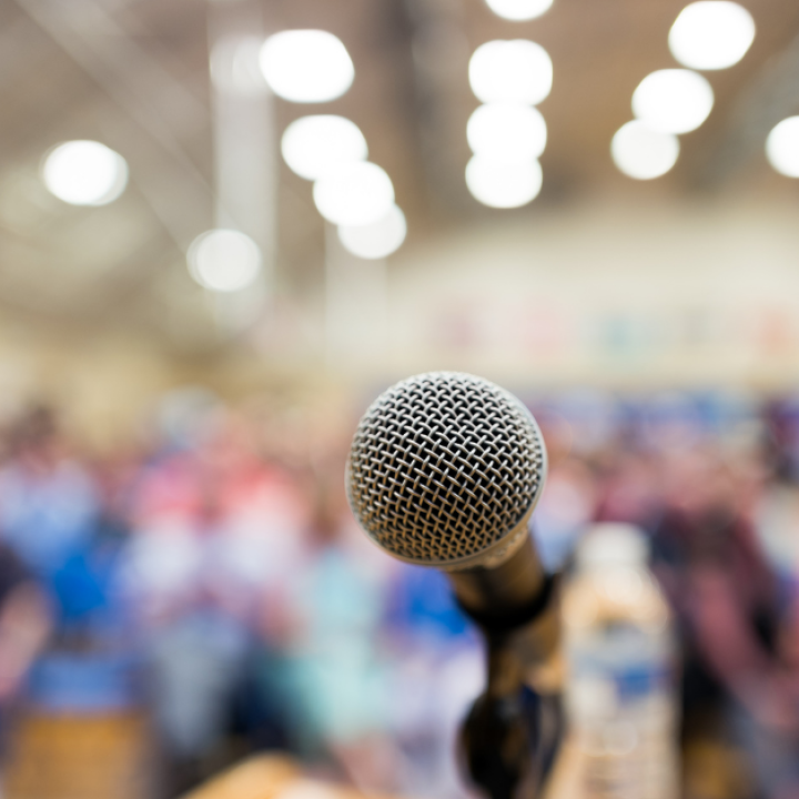 A microphone in front of a seated crowd